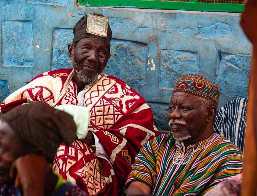 Naa Bohagu (à esquerda), chefe supremo e senhor do tradicional reino de Mamprugu, no norte de Gana, fica do lado de fora de seu palácio com o Taraana (assistente) ao seu lado. (Foto: William Haun / IMB)