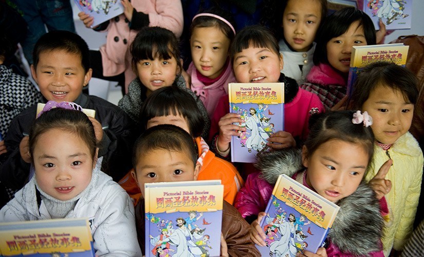 Crianças chinesas com bíblias infantis 