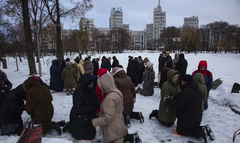 Ucranianos ajoelham-se e oram na neve em praça da cidade de Kharkov (Foto: Reprodução/IMB)