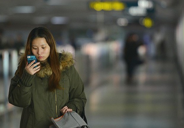 Jovem chinesa usando o seu mobile onde tem acesso à Bíblia